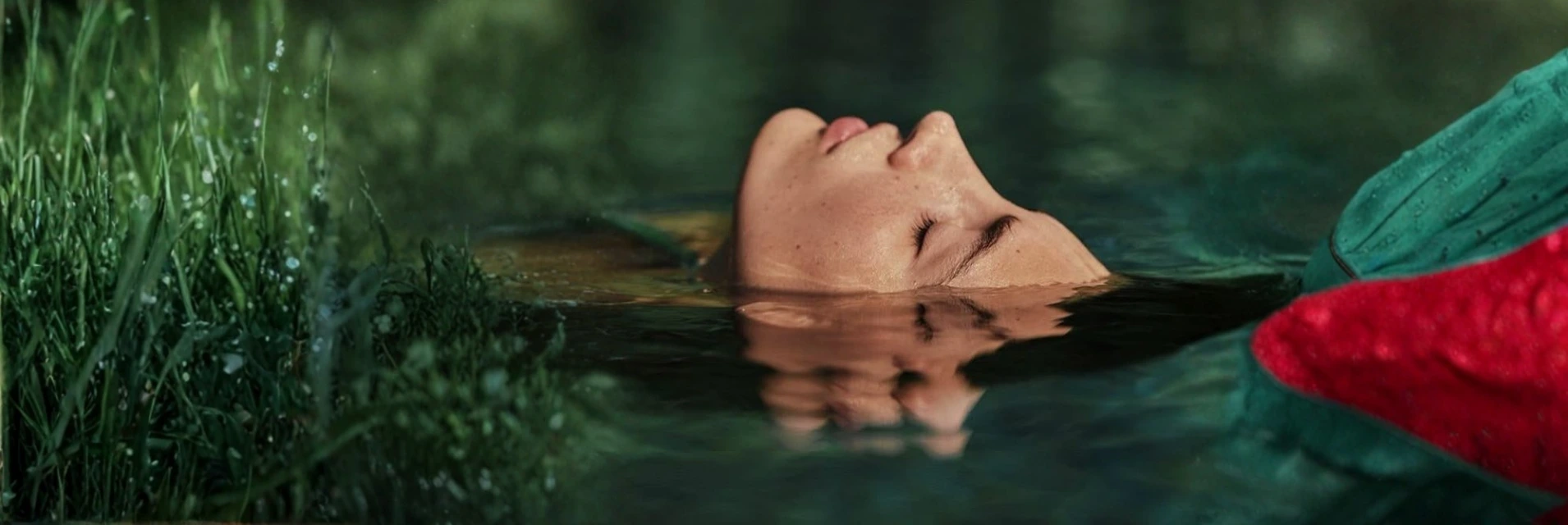 Egy európai nő lebeg a víz tetején, csukott szemmel pihen.